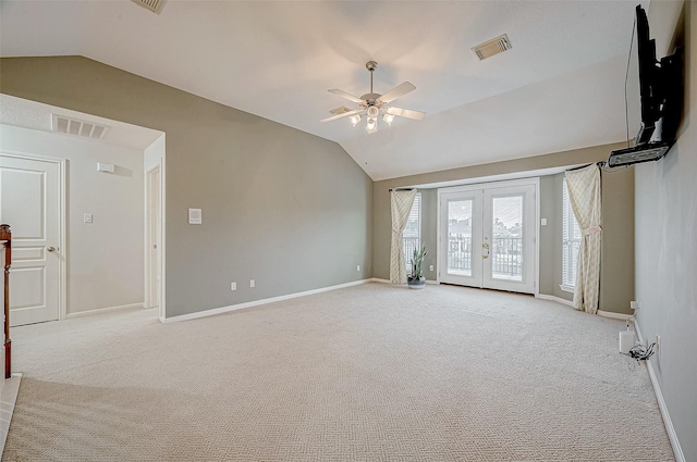 unfurnished living room featuring lofted ceiling, light carpet, ceiling fan, and french doors