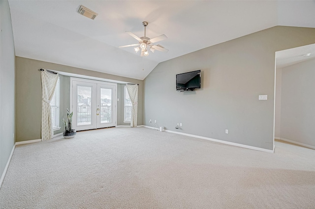 carpeted spare room with lofted ceiling, french doors, and ceiling fan