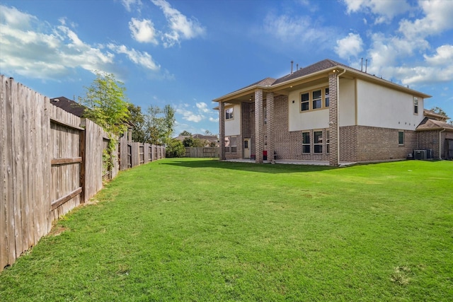 rear view of house featuring central AC and a yard