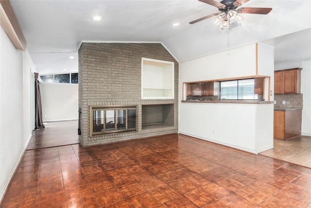 9219 Timberside Dr, Houston, TX 77025 - unfurnished living room with a ceiling fan, vaulted ceiling, a brick fireplace, baseboards, and recessed lighting