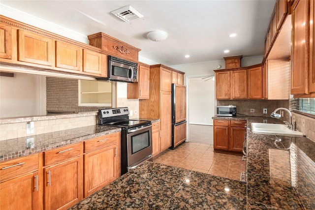 kitchen with light tile patterned flooring, sink, crown molding, stainless steel appliances, and backsplash