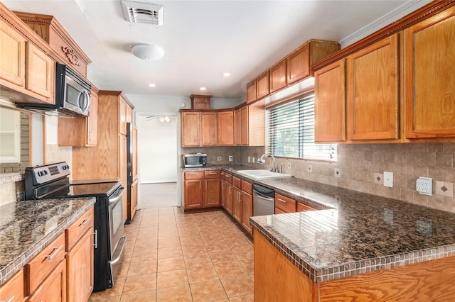 9219 Timberside Dr, Houston, TX 77025 - kitchen featuring stainless steel appliances, a sink, tasteful backsplash, brown cabinets, and recessed lighting