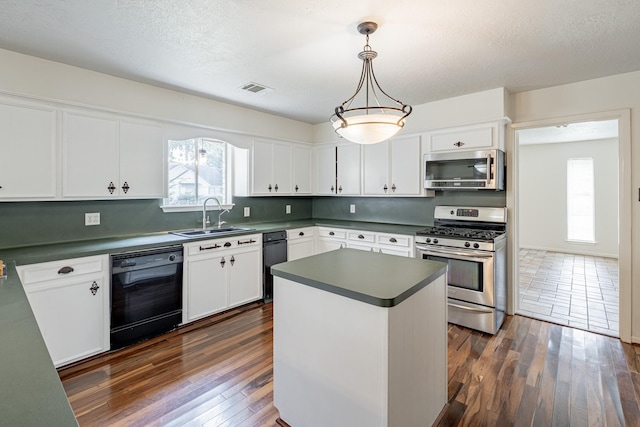 kitchen with sink, backsplash, stainless steel appliances, white cabinets, and decorative light fixtures