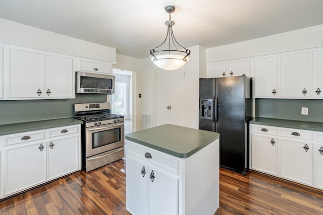 kitchen featuring a kitchen island, pendant lighting, white cabinets, stainless steel appliances, and dark wood-type flooring