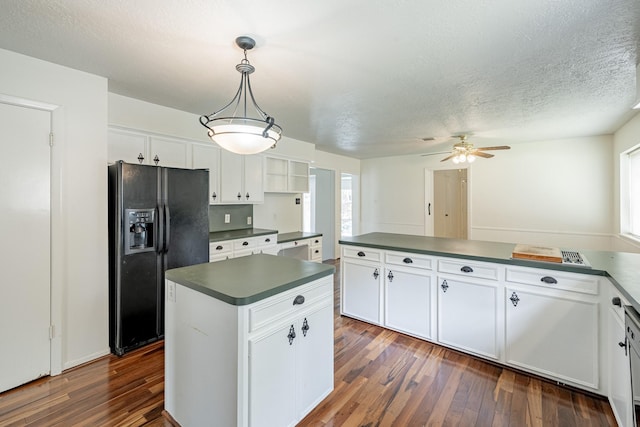 kitchen with pendant lighting, a wealth of natural light, black refrigerator with ice dispenser, and white cabinets