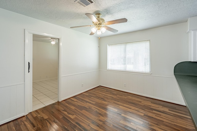 unfurnished bedroom with dark hardwood / wood-style flooring, a textured ceiling, and ceiling fan