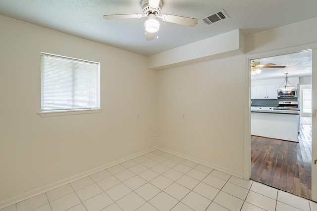 spare room with light tile patterned floors and ceiling fan