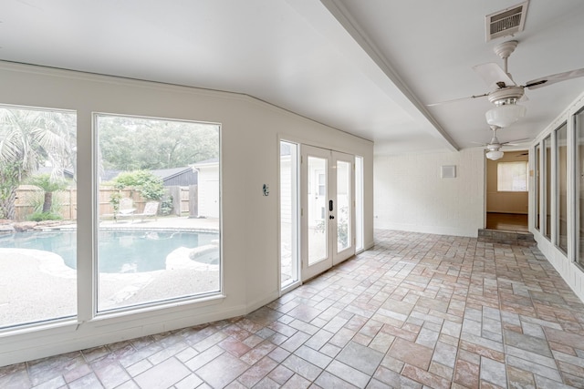 interior space with vaulted ceiling, french doors, and ceiling fan