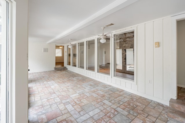 unfurnished sunroom featuring ceiling fan