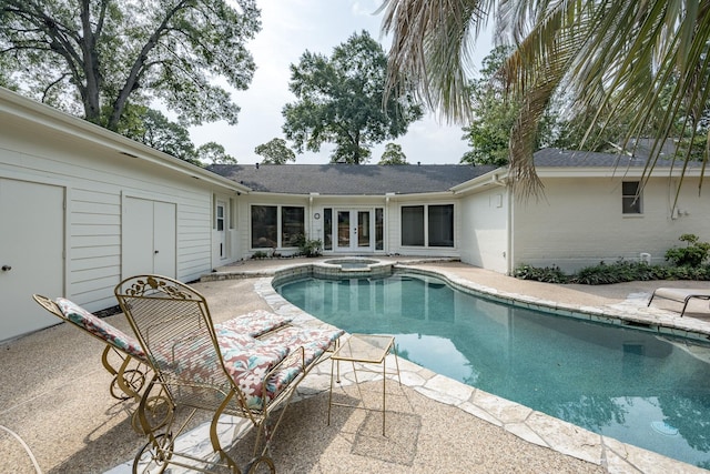 view of pool with french doors, an in ground hot tub, and a patio area