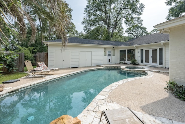 view of swimming pool with an in ground hot tub, a patio area, and french doors