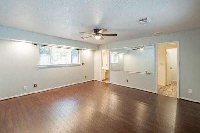 empty room with ceiling fan, a textured ceiling, and dark hardwood / wood-style flooring