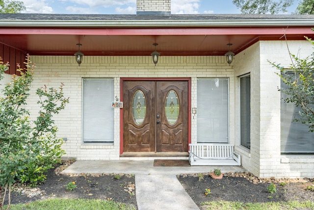 view of exterior entry with covered porch