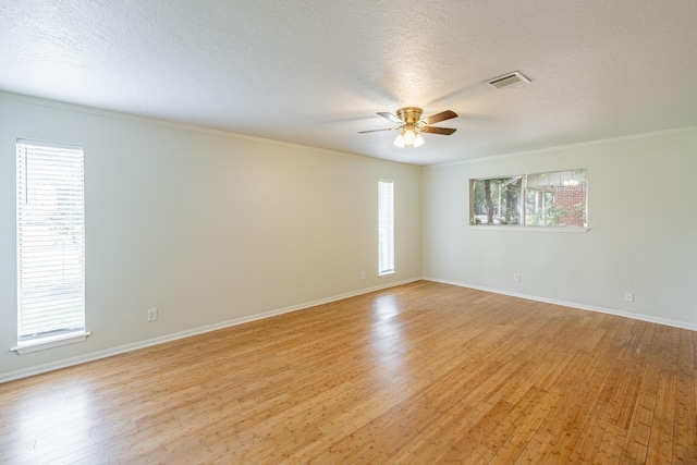 spare room featuring ceiling fan, crown molding, a textured ceiling, and light hardwood / wood-style floors