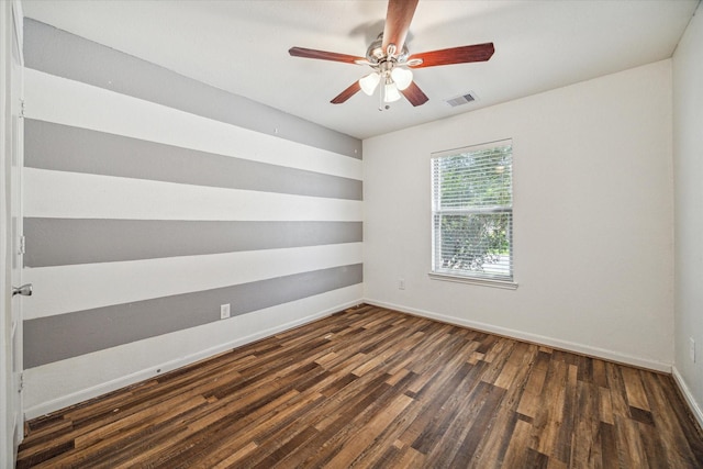 spare room featuring dark wood-type flooring and ceiling fan