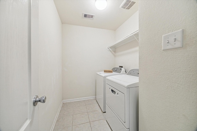 washroom with separate washer and dryer and light tile patterned flooring