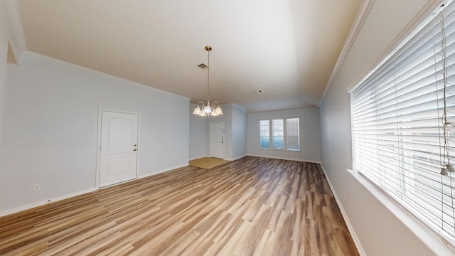 unfurnished dining area featuring ornamental molding, a chandelier, and light hardwood / wood-style floors