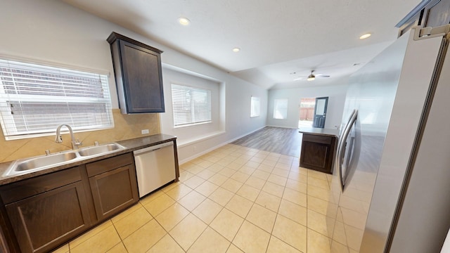 kitchen featuring sink, light tile patterned floors, ceiling fan, dark brown cabinetry, and stainless steel appliances