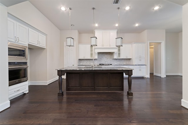 kitchen with stainless steel appliances, a kitchen island with sink, and a kitchen bar