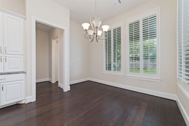 unfurnished dining area with dark wood-type flooring and a chandelier