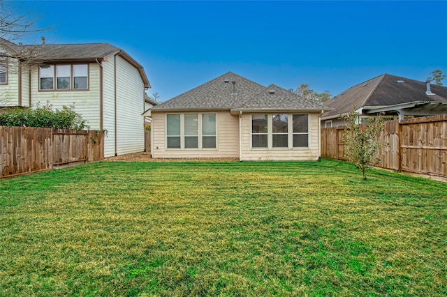 rear view of house featuring a lawn