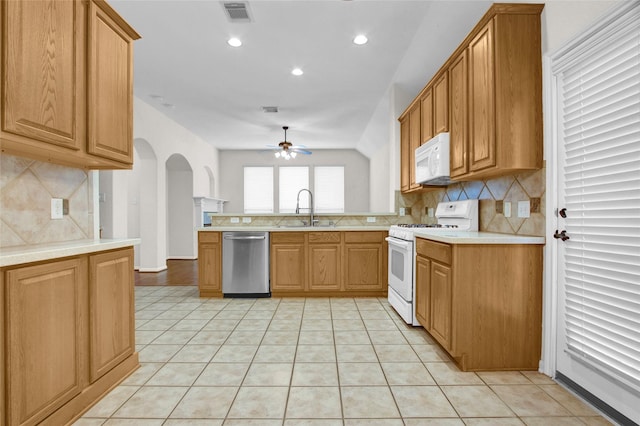 kitchen with sink, white appliances, light tile patterned floors, ceiling fan, and backsplash