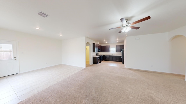 unfurnished living room with ceiling fan and light colored carpet