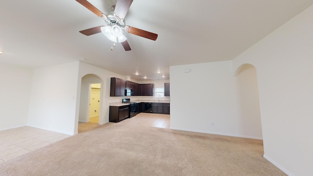 unfurnished living room with light colored carpet and ceiling fan