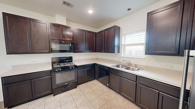 kitchen with light tile patterned floors, sink, dark brown cabinets, and black appliances