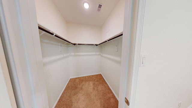 walk in closet featuring light colored carpet