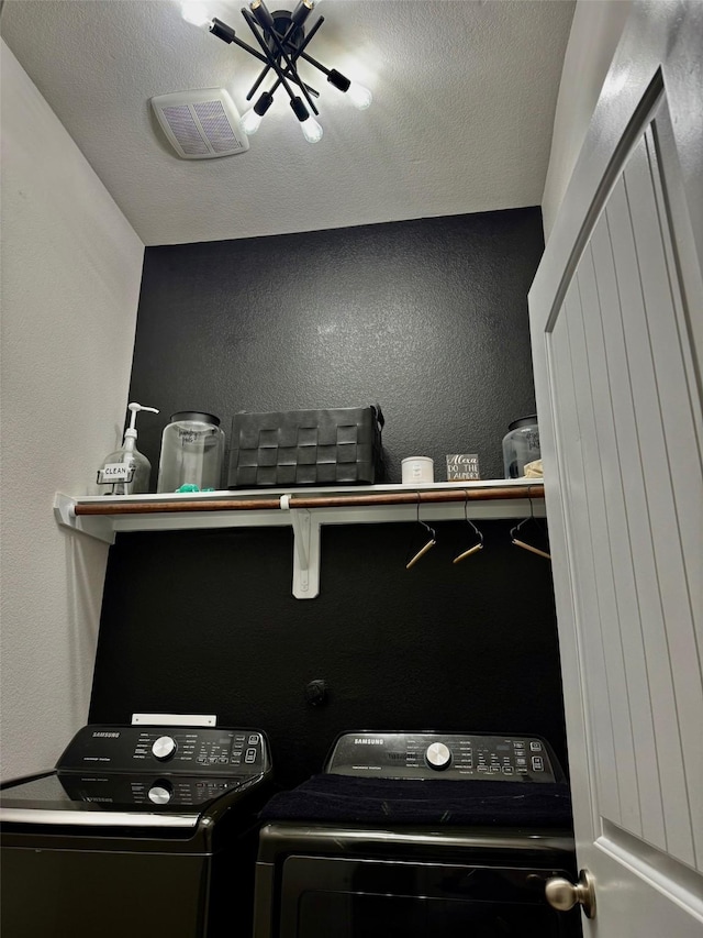 laundry area featuring washer and dryer and a textured ceiling