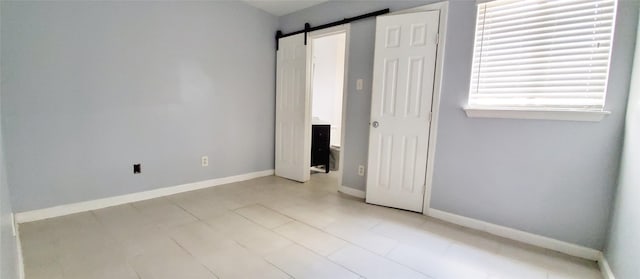 unfurnished bedroom featuring a barn door