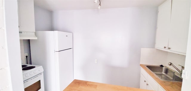 kitchen with rail lighting, sink, extractor fan, white appliances, and white cabinets