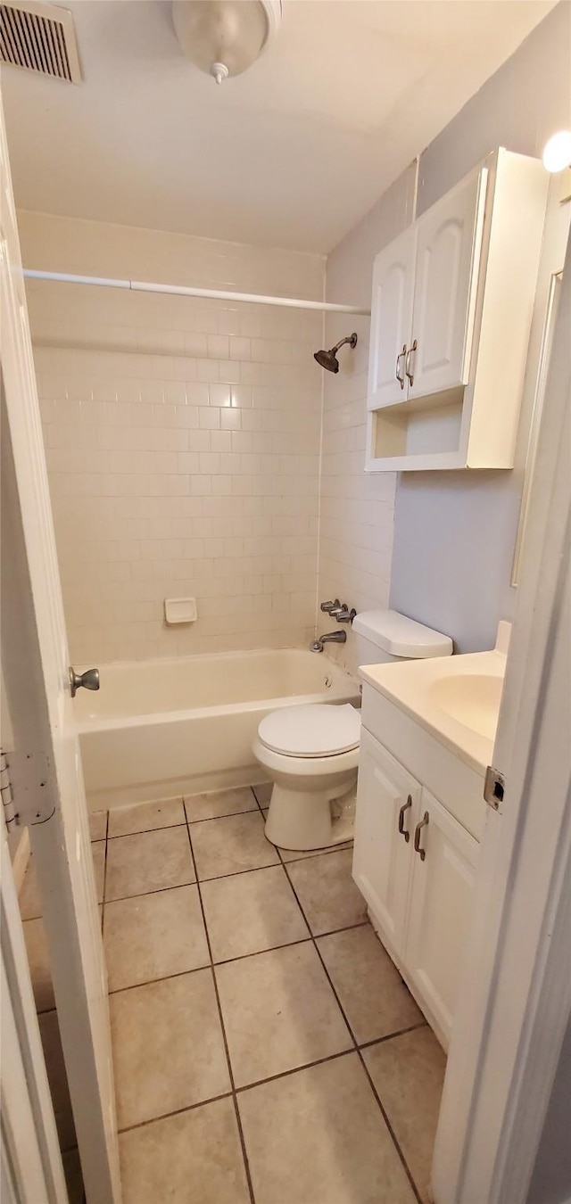 full bathroom featuring tiled shower / bath, tile patterned floors, toilet, and vanity