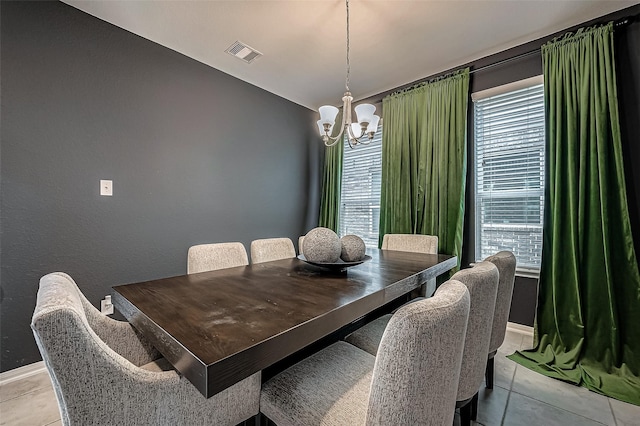 tiled dining space featuring an inviting chandelier and a wealth of natural light