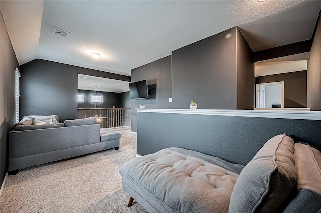 living room featuring vaulted ceiling, a textured ceiling, and carpet