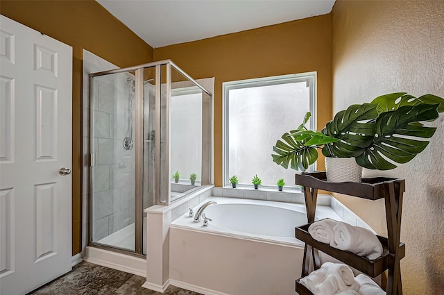 bathroom with shower with separate bathtub and a wealth of natural light