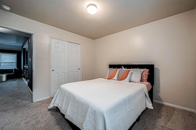 carpeted bedroom with a textured ceiling and a closet