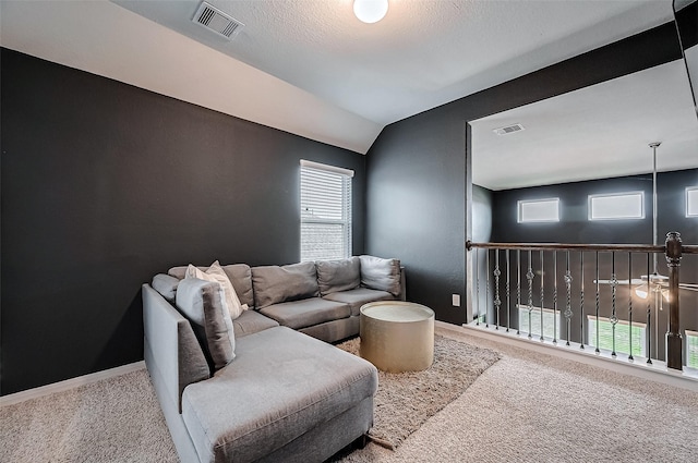 carpeted living room featuring lofted ceiling and a textured ceiling