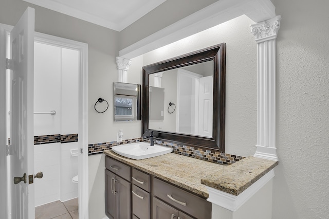 bathroom featuring tile patterned floors, toilet, ornamental molding, vanity, and backsplash