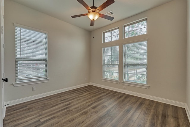 unfurnished room with baseboards, dark wood finished floors, and a ceiling fan