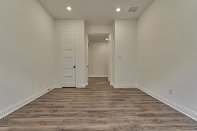 spare room with recessed lighting, wood finished floors, visible vents, and baseboards