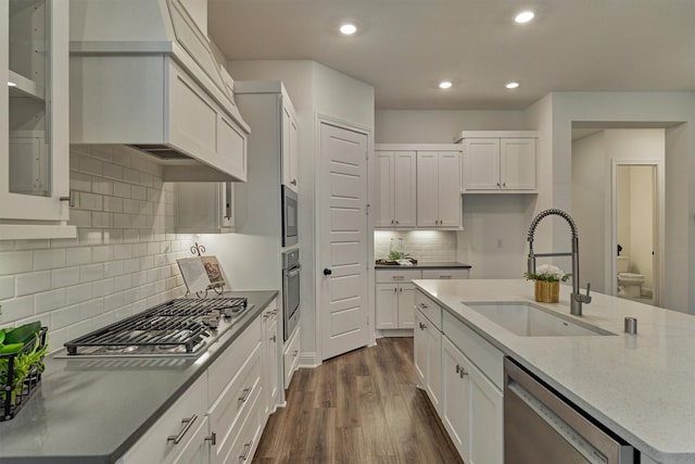 kitchen featuring sink, white cabinetry, appliances with stainless steel finishes, dark hardwood / wood-style floors, and decorative backsplash