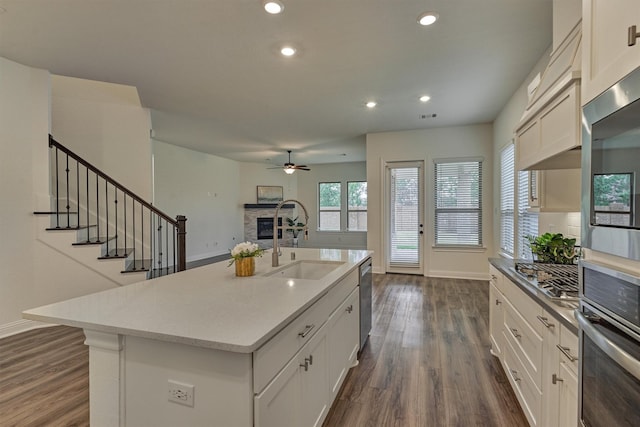 kitchen featuring an island with sink, appliances with stainless steel finishes, and white cabinets