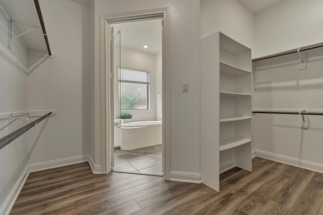 spacious closet with dark wood finished floors