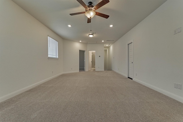 spare room featuring light colored carpet and ceiling fan