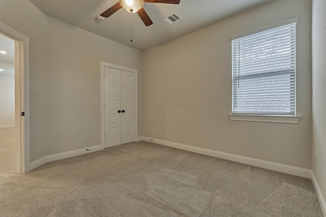 unfurnished bedroom featuring carpet floors, baseboards, visible vents, and a closet