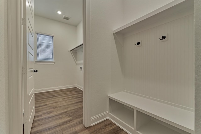 mudroom featuring visible vents, baseboards, and dark wood-type flooring