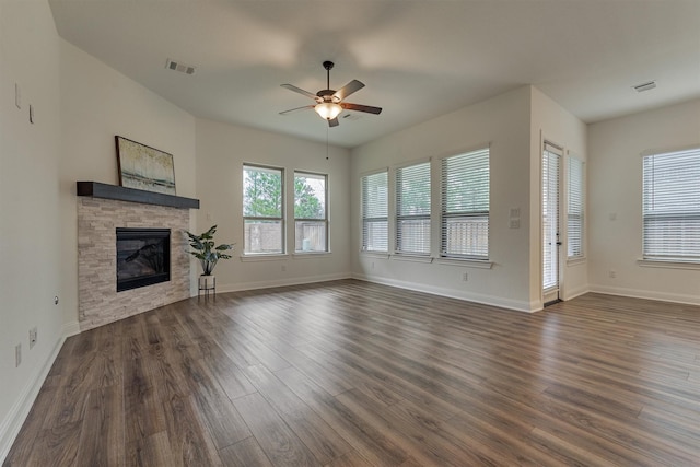 unfurnished living room with baseboards, visible vents, a ceiling fan, dark wood-style floors, and a fireplace