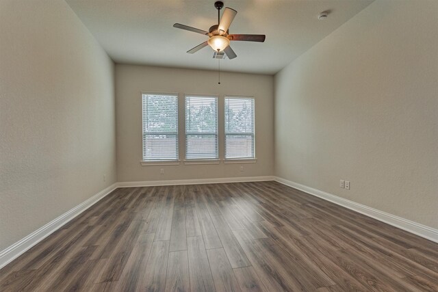 spare room with dark hardwood / wood-style floors and ceiling fan